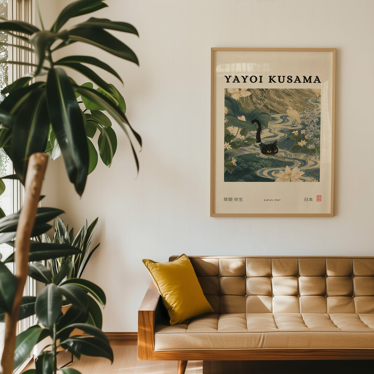 Black cat swimming lotus river poster in an oak frame above a tan tufted leather sofa with a mustard cushion
