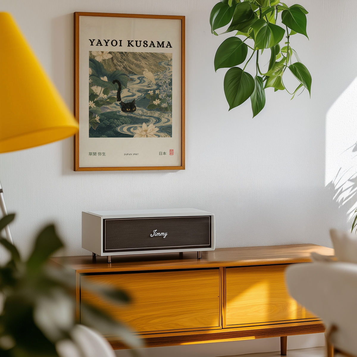 Black cat swimming lotus river poster in an oak frame above a teak mid-century sideboard with trailing pothos