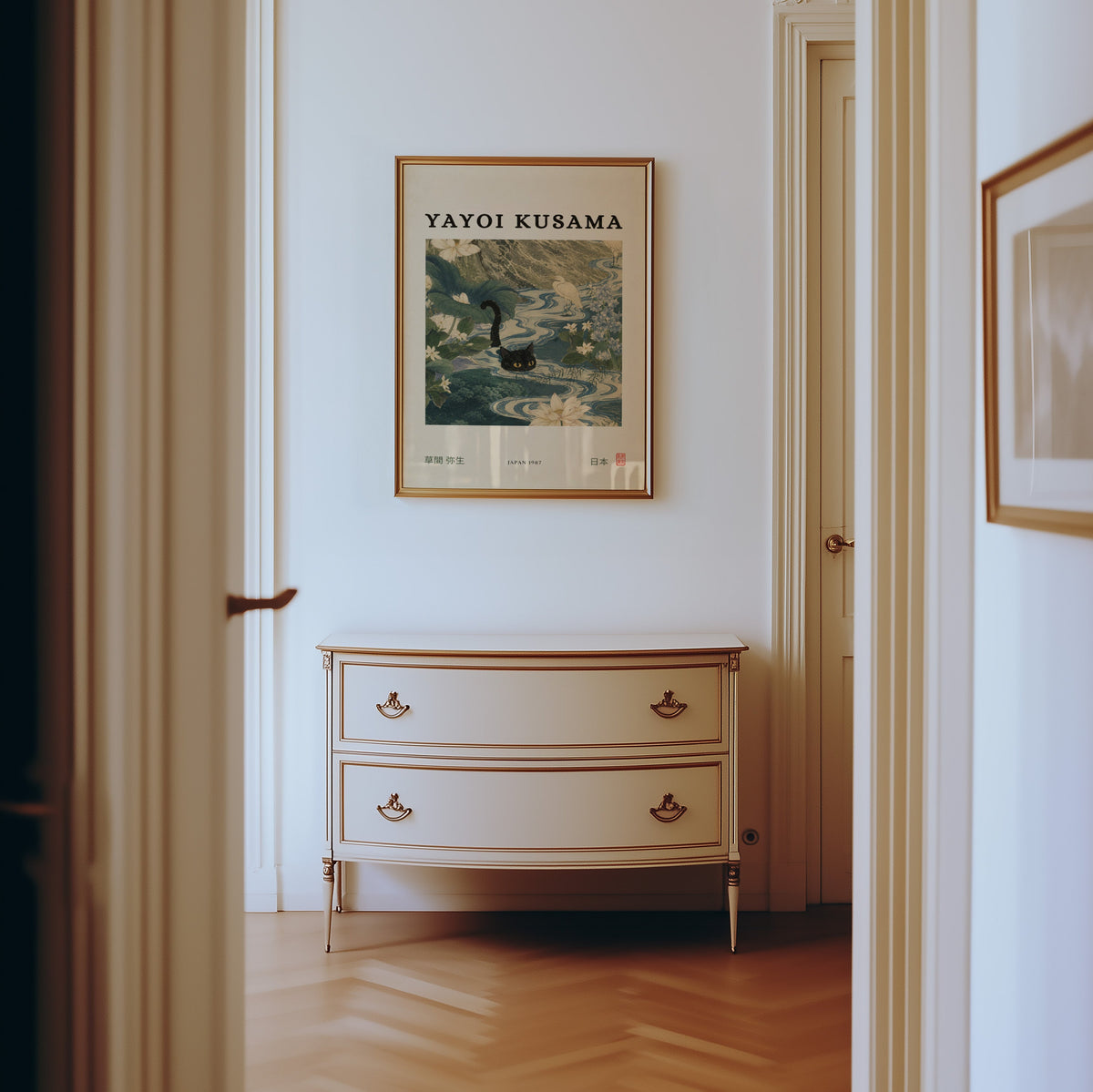 Black cat swimming lotus river poster shown in a gold frame in a hallway above a cream dresser