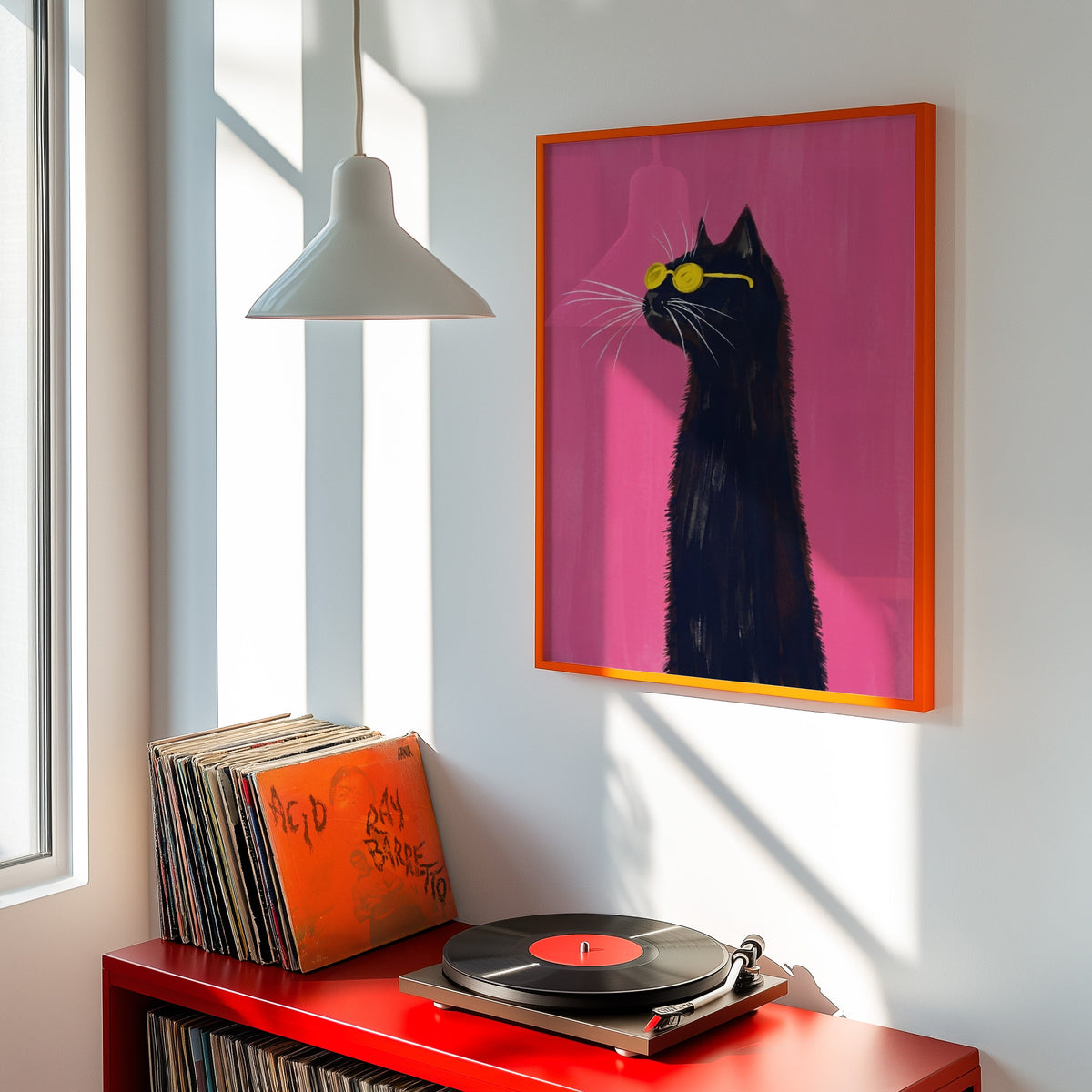 Black cat sunglasses print shown in an orange frame above a red record cabinet and turntable