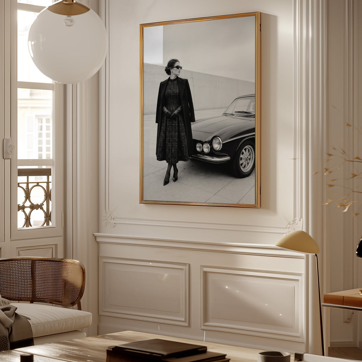 Black and white woman in tweed coat by classic car print shown in a gold frame in a Parisian paneled living room