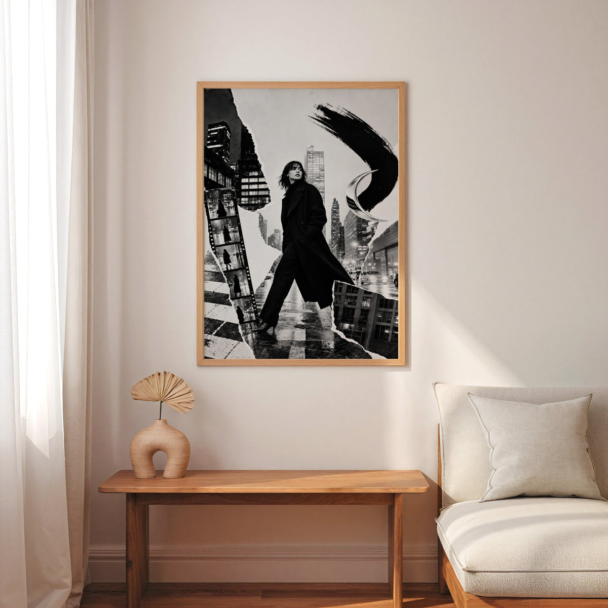 Woman in black coat torn paper collage print in an oak frame above a narrow console with an arched vase