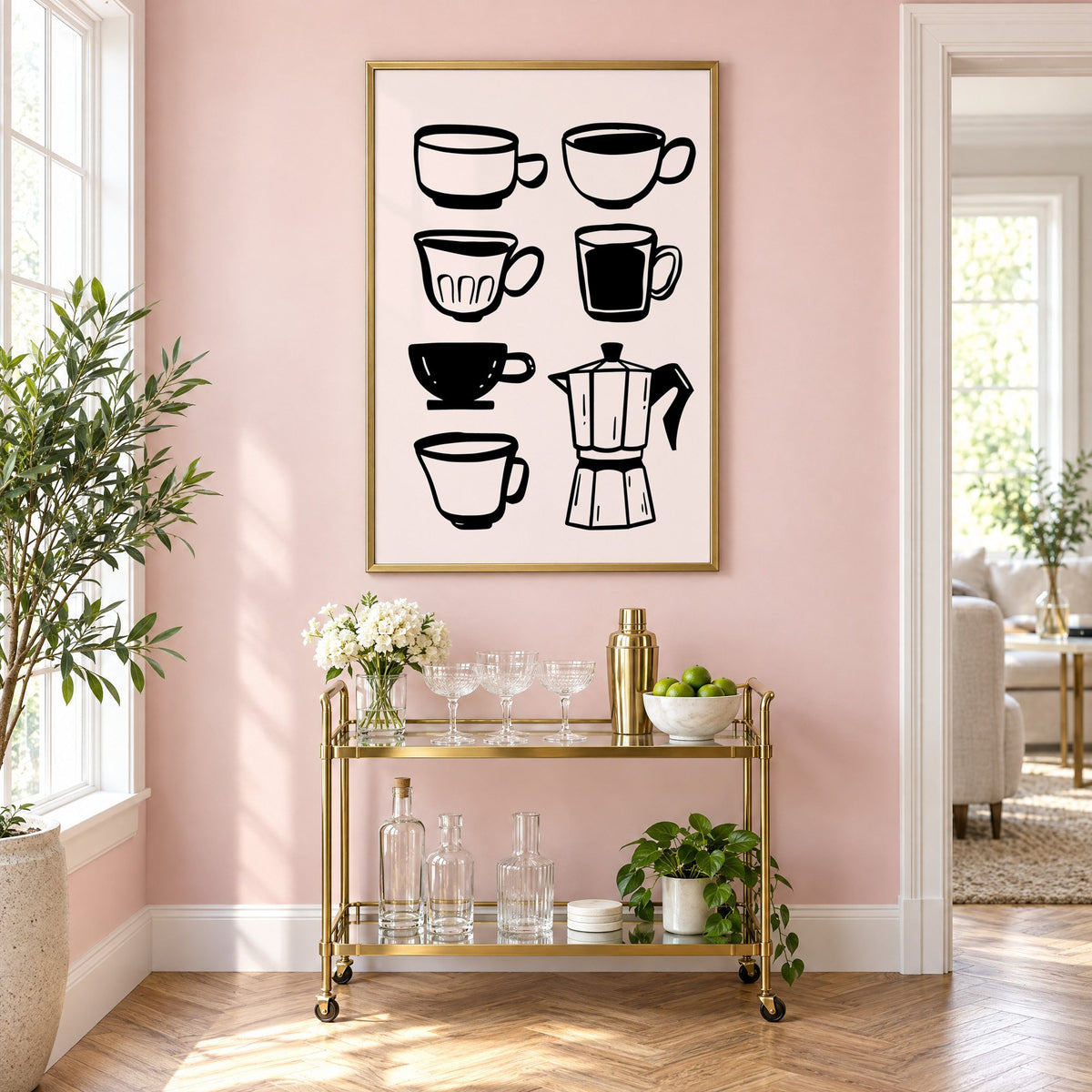 Black coffee cups and moka pot print in a brass frame above a gold bar cart on a blush pink wall