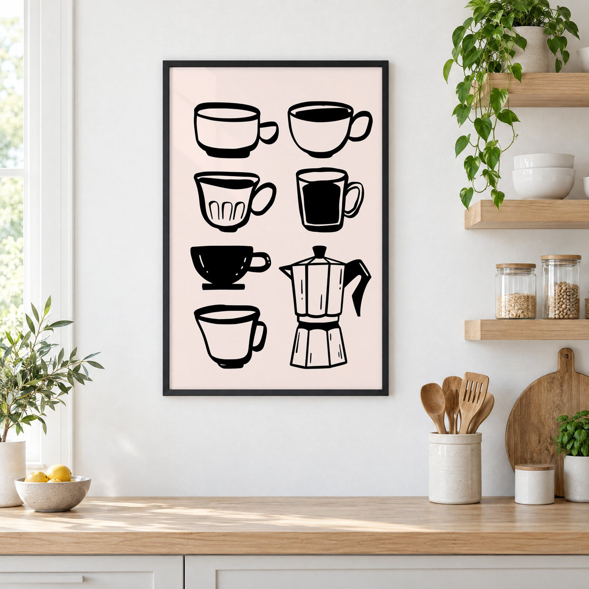 Black coffee cups and moka pot print in a black frame in a white kitchen beside open wood shelves and glass jars