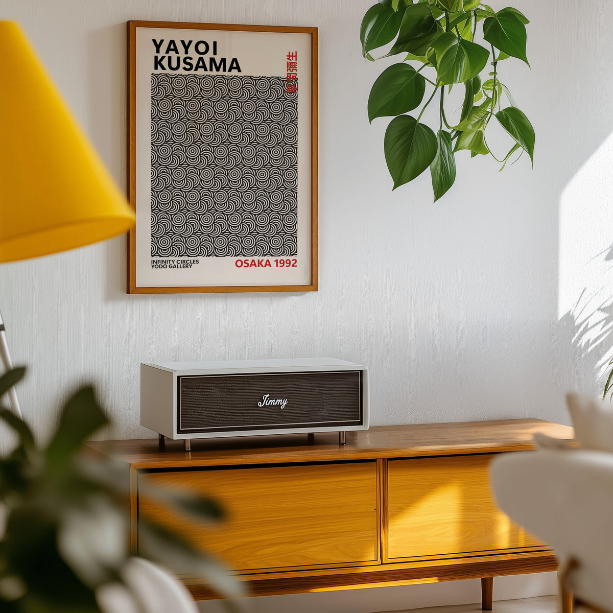 Yayoi Kusama inspired black concentric circles print over a wooden cabinet with a speaker and trailing plant