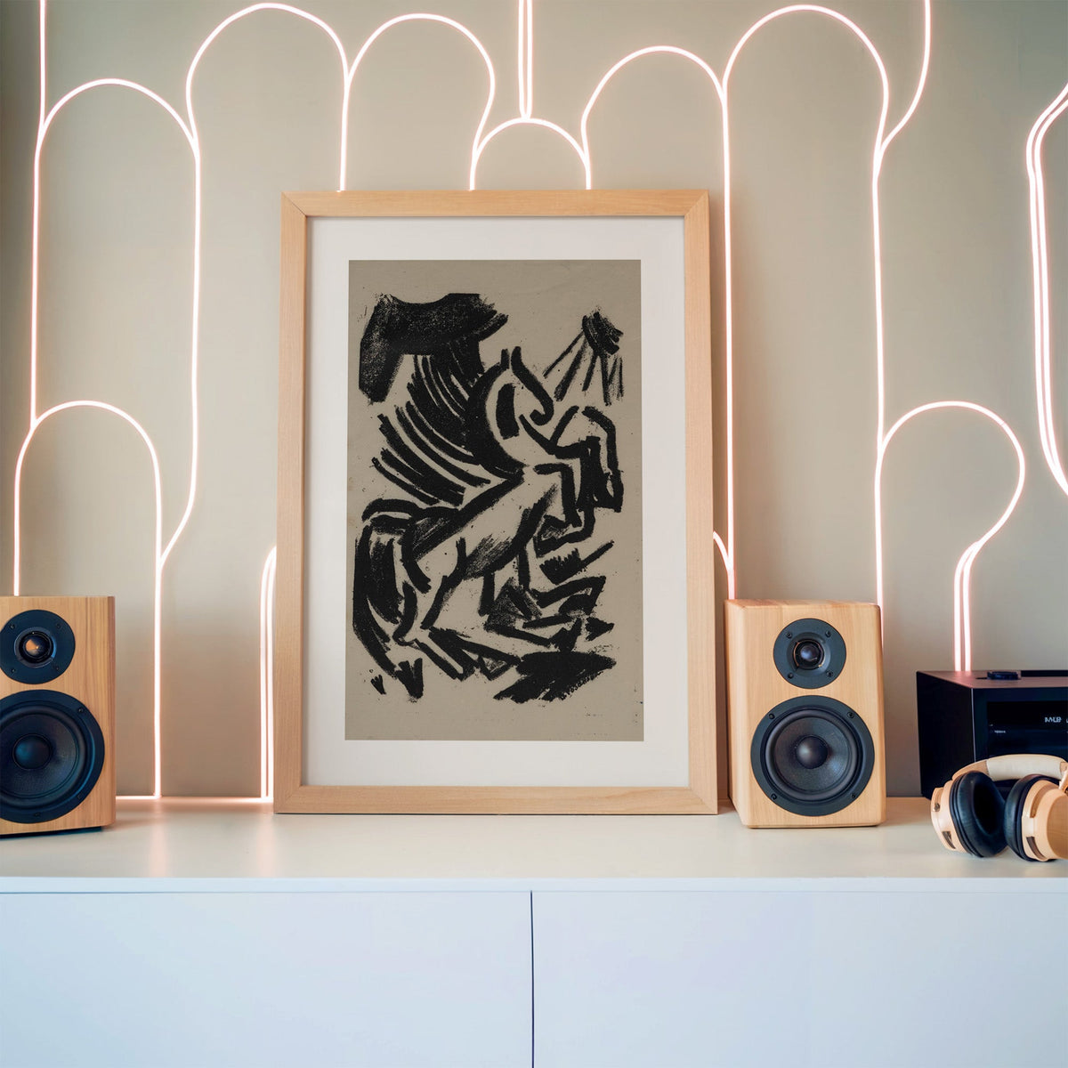 Black crayon rearing animal and sun print in a pine frame between wooden speakers by a neon arch light wall