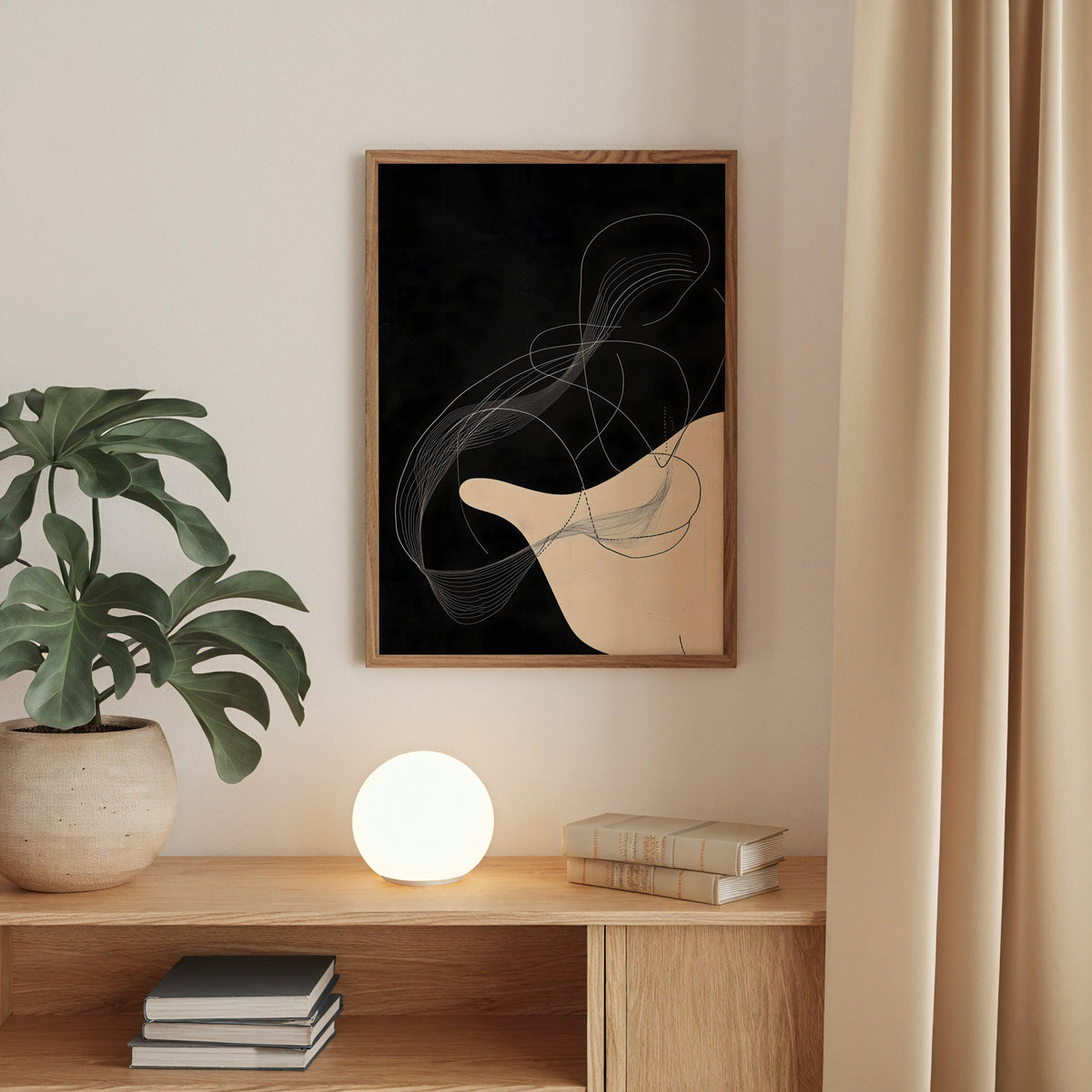 Black and cream flowing line art abstract print in a walnut frame above an oak cabinet with a glowing globe lamp