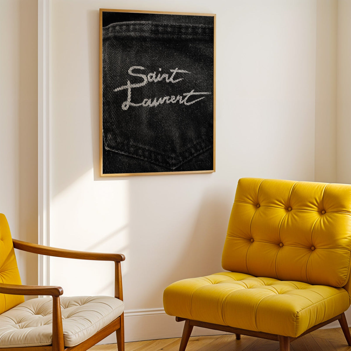 White script stitched on black denim pocket print shown in a gold frame above a mustard yellow tufted armchair