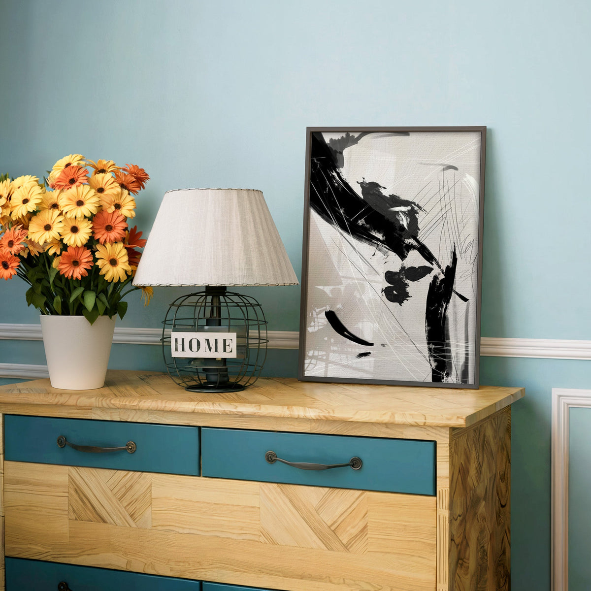 Black diagonal brush and scratch lines print in a charcoal frame on a teal dresser beside orange and yellow daisies