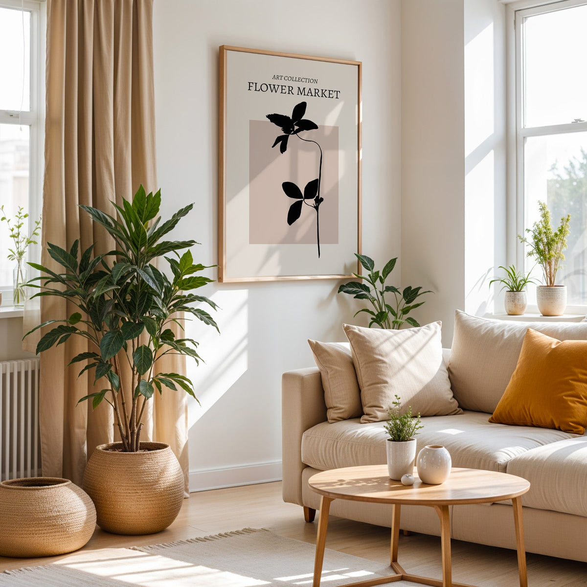 Black flower stem on blush square botanical print in an oak frame above a cream sofa beside a tall plant in a woven pot