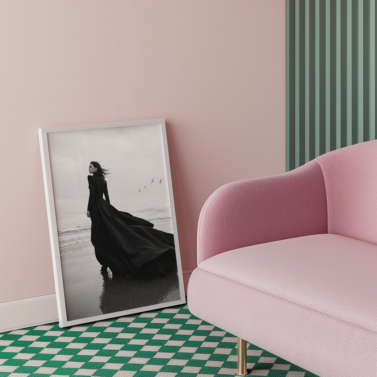 Woman in long black gown on a windy beach print in a white frame beside a pink armchair on a checkered floor
