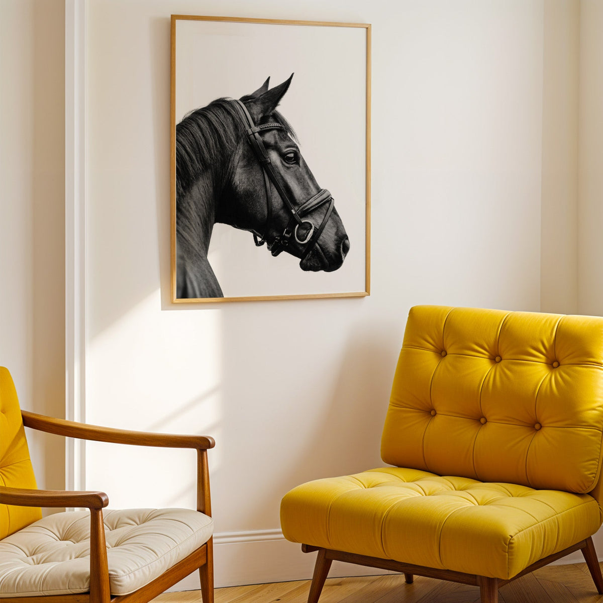 Black horse head in leather bridle profile print shown in a gold frame above a mustard yellow tufted armchair