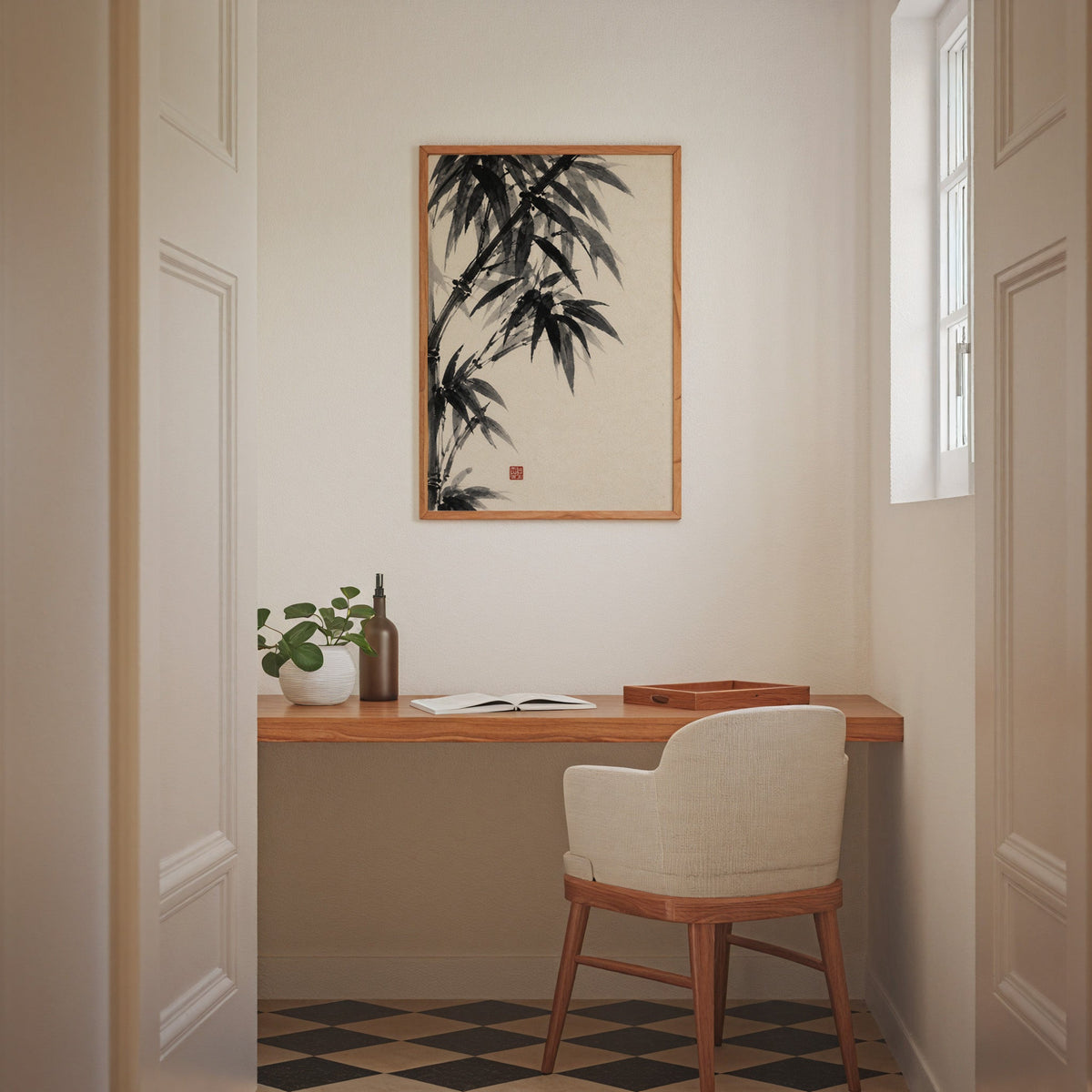 Black ink bamboo sumi-e poster in an oak frame above a wall-mounted desk in a home office nook
