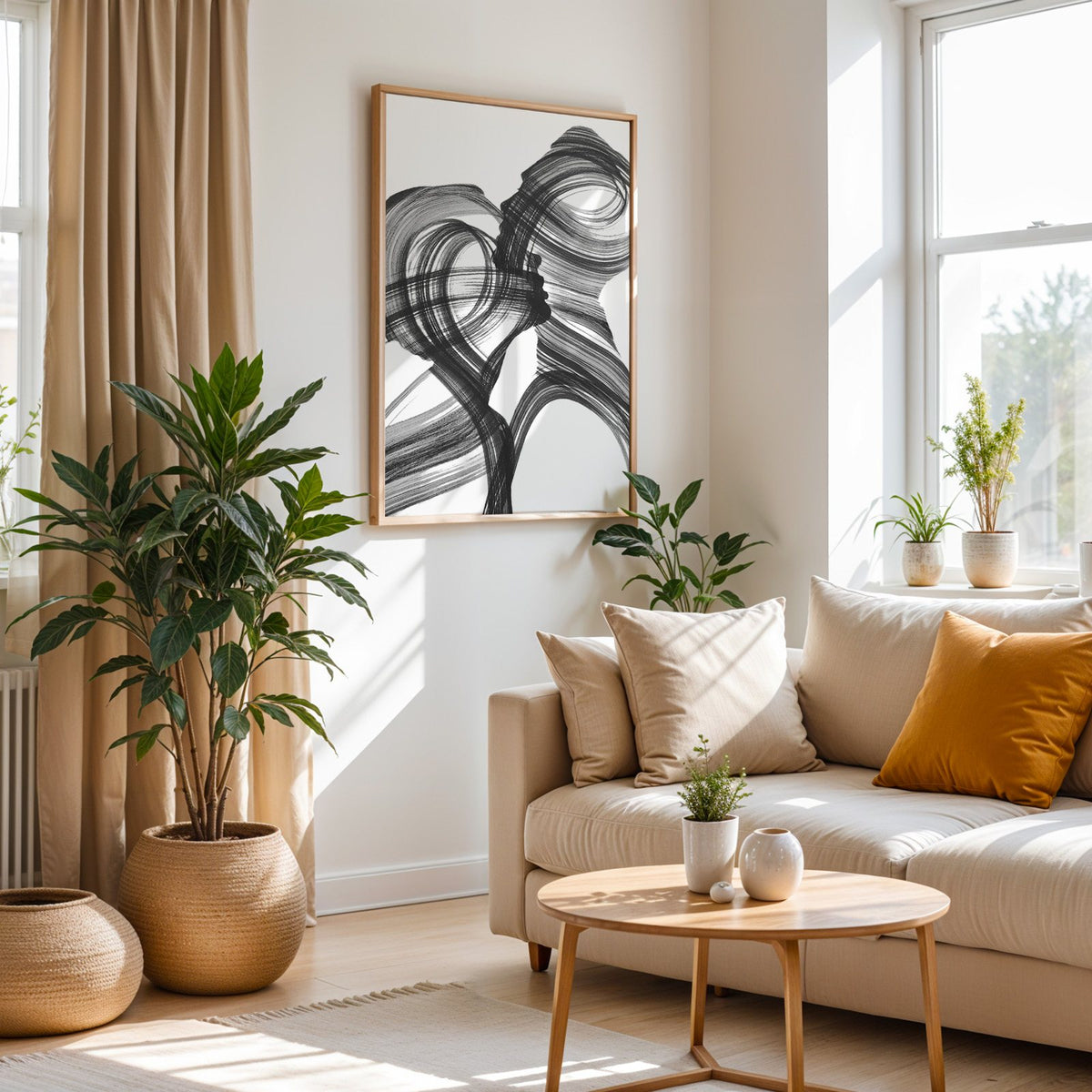 Black ink brush swirl abstract print in an oak frame above a cream sofa beside woven planters