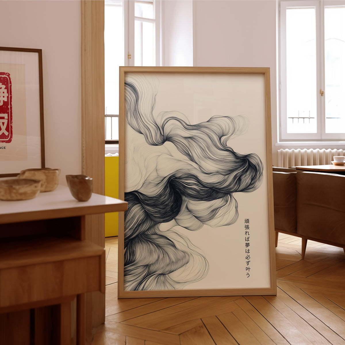 Black ink swirl dreams proverb print in an oak frame on the parquet floor of a sunlit living room