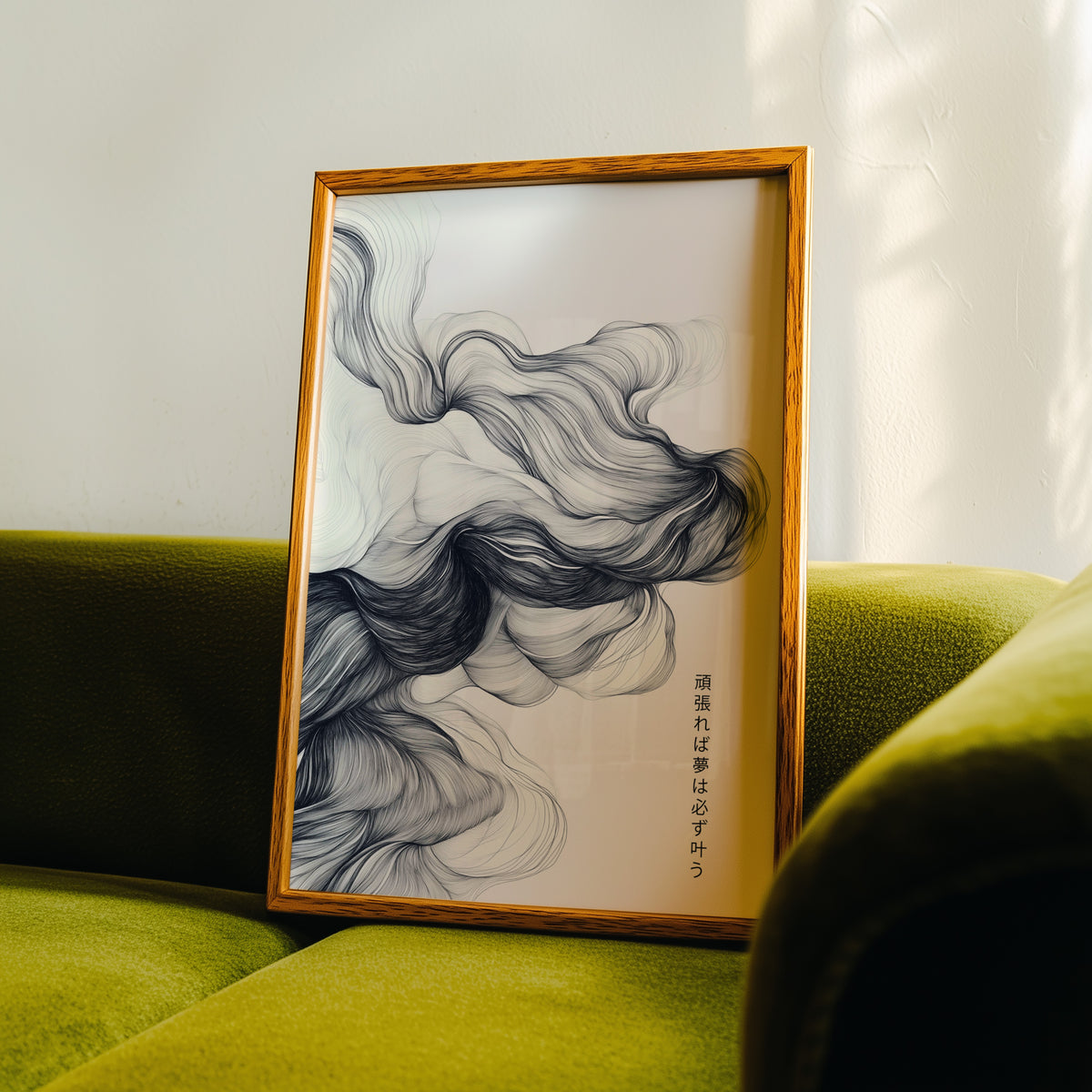 Black ink swirl dreams proverb print in an oak frame propped on a green velvet sofa