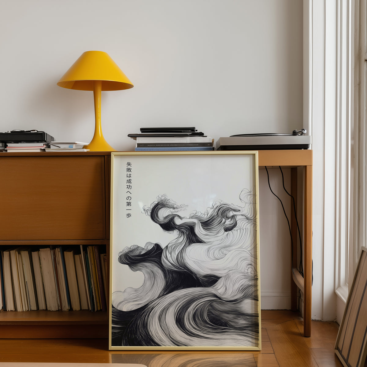 Ink swirl failure and success proverb print shown in a gold frame below a teak desk with a yellow lamp