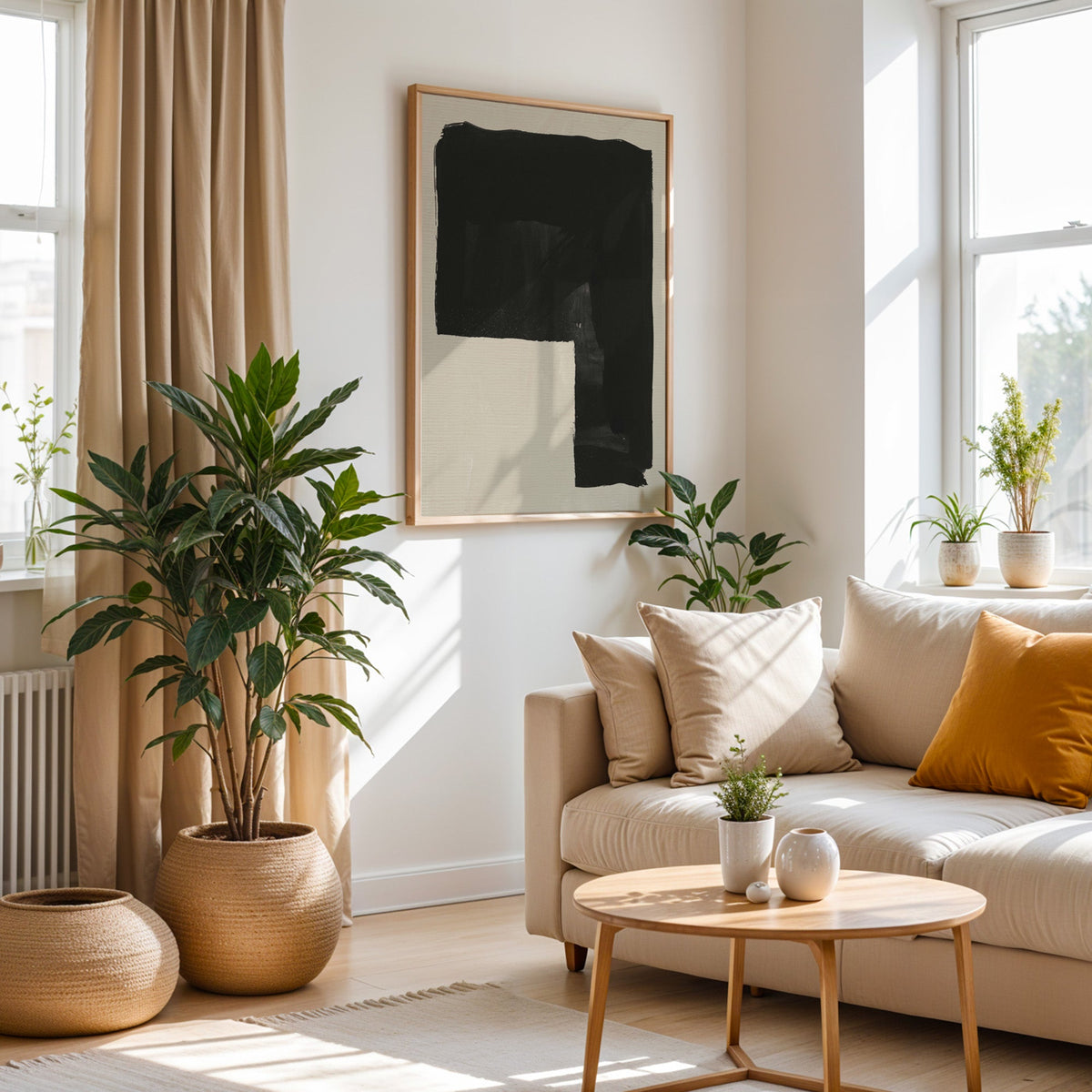 Black inverted L block on greige print in an oak frame above a cream sofa beside a tall plant in a woven pot