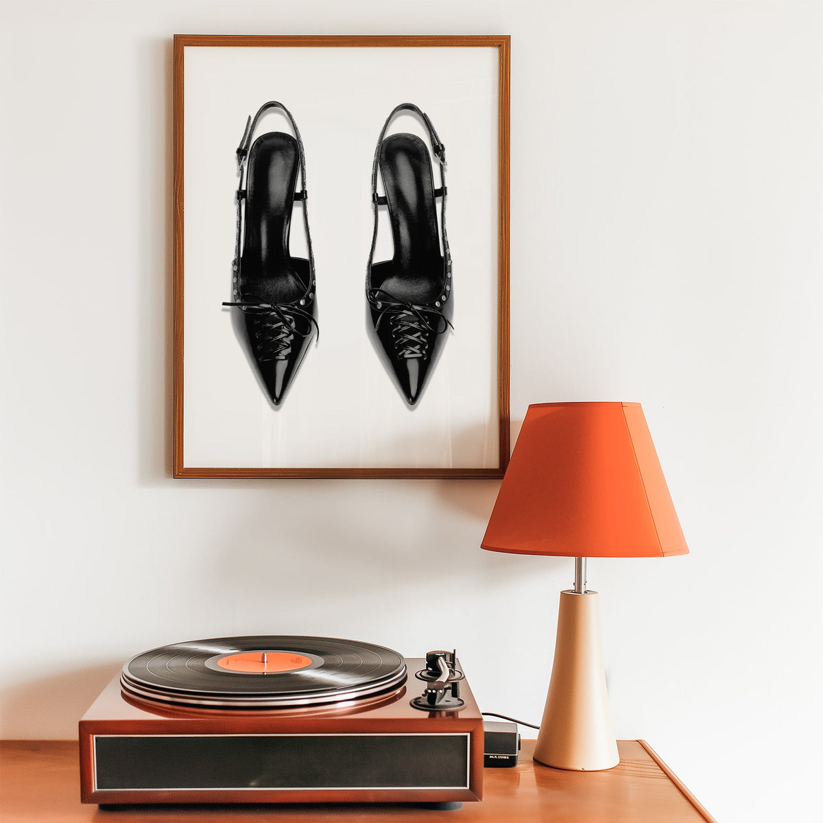 Black lace-up studded slingback heels print in a walnut frame above a record player and orange lamp