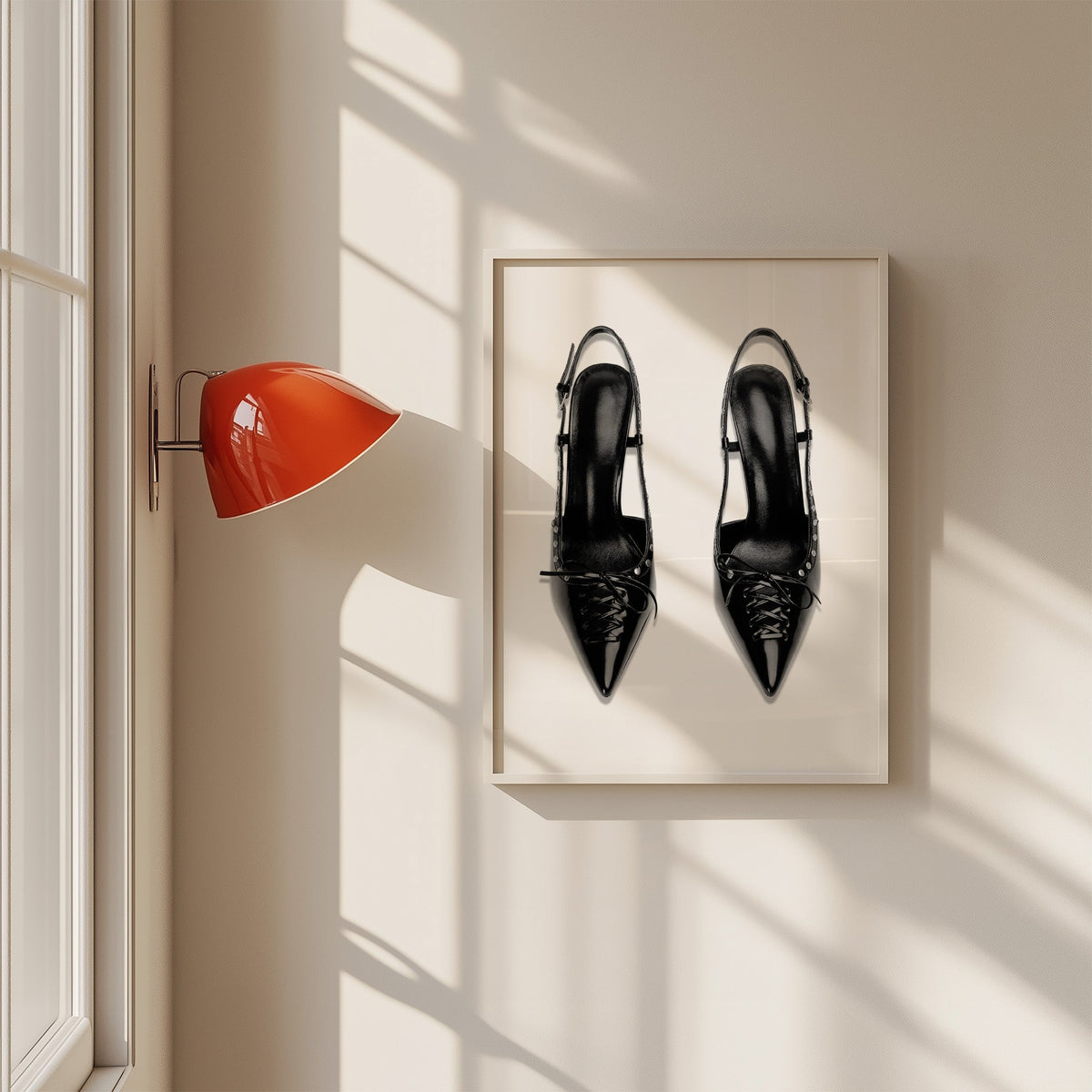 Black lace-up studded slingback heels print in a white frame on a sunlit wall beside a red sconce