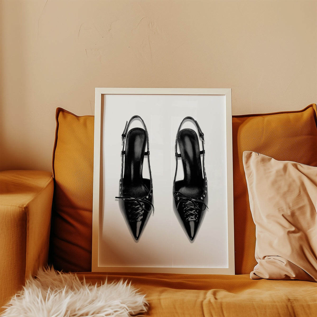 Black lace-up studded slingback heels print in a white frame leaning on a mustard velvet sofa
