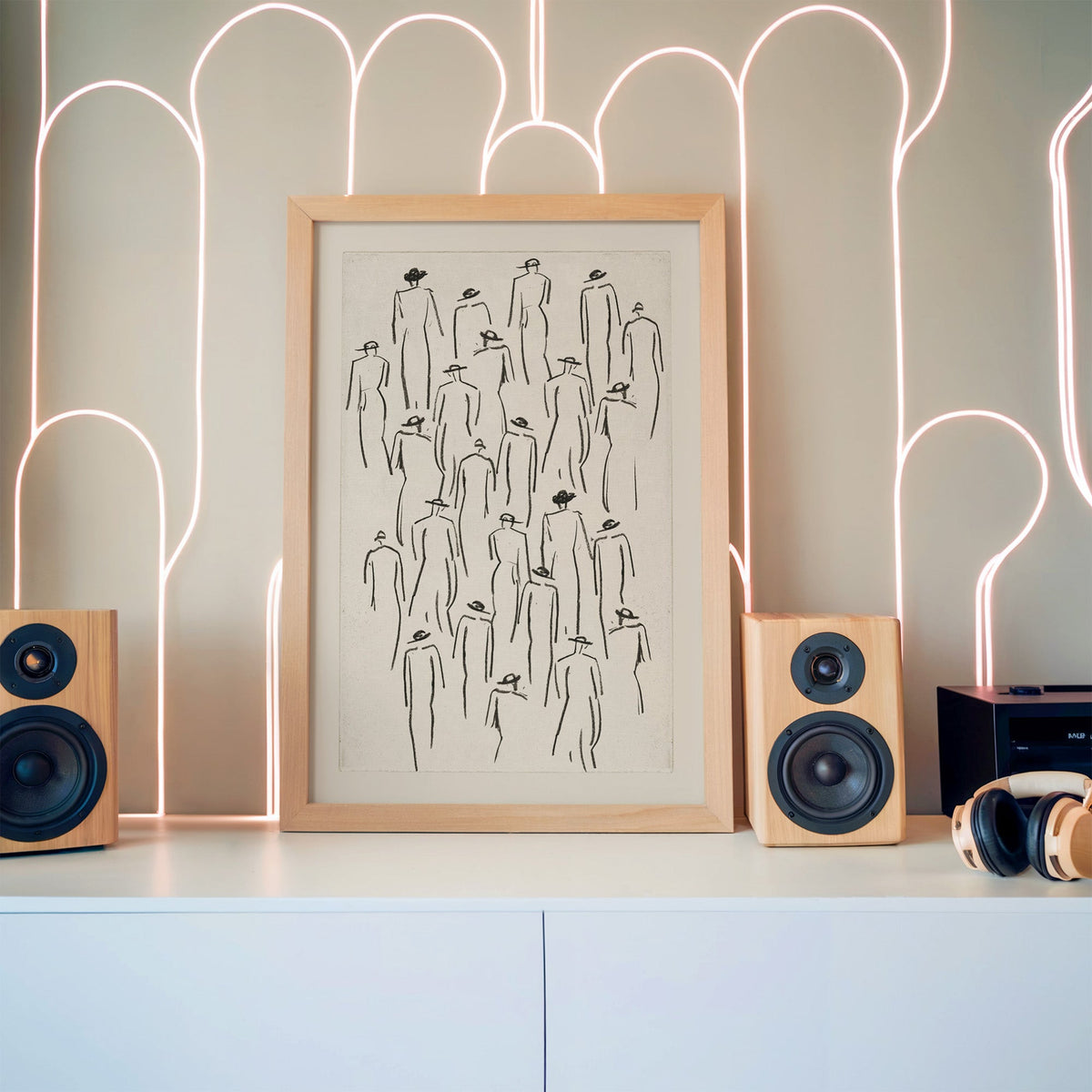 Black line crowd of hat figures sketch print in a pine frame between wooden speakers by a neon arch light wall