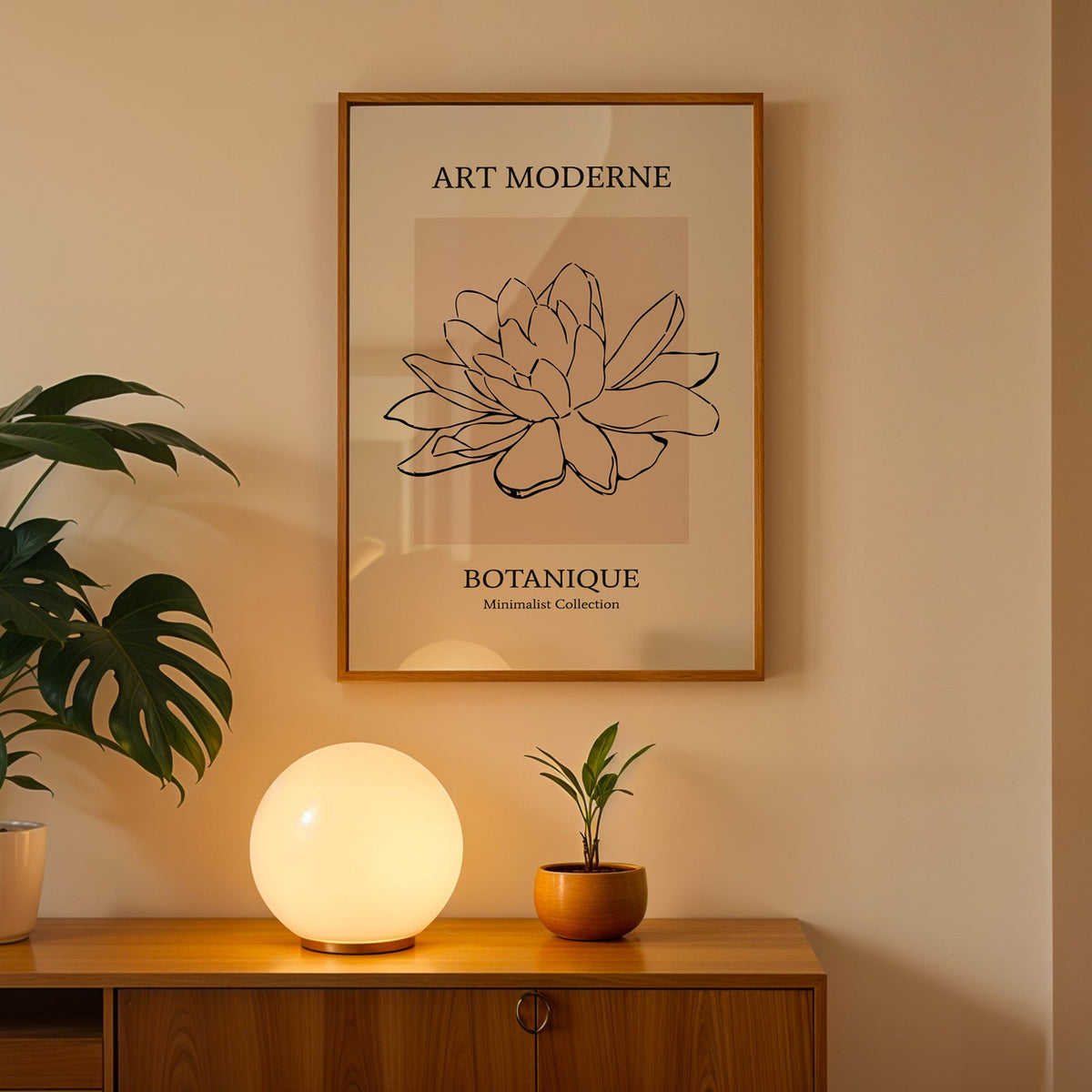 Black line flower on blush panel botanical print in an oak frame above a teak cabinet with a globe lamp and monstera