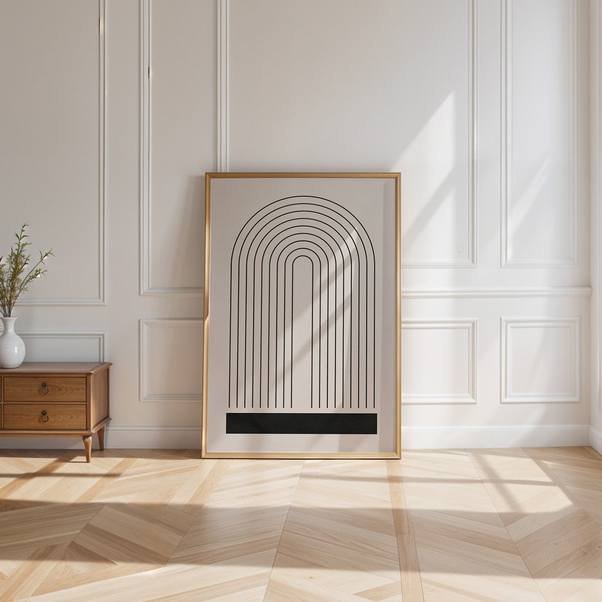 Black line rainbow arch minimalist print shown in a gold frame leaning on a paneled white wall in sunlight