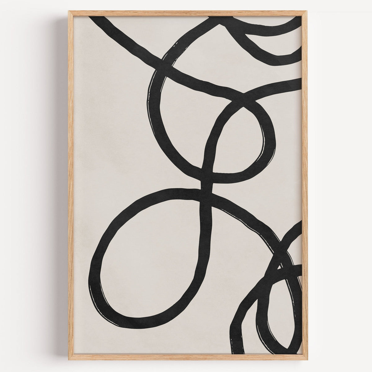 Black looping brushstroke lines minimalist print in a light oak frame on a plain white wall