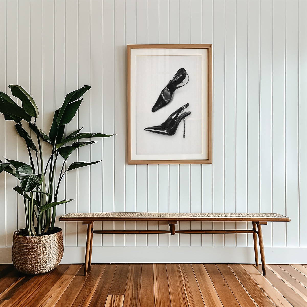 Black patent slingbacks with silver heels print in a wood frame with a white mat above a cane bench