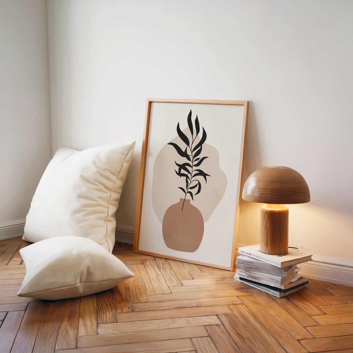 Black slender leaves in round vase boho print in a light wood frame on a herringbone floor by a wooden mushroom lamp