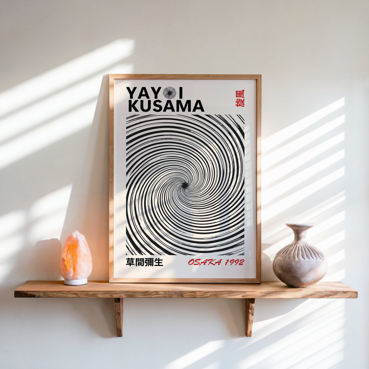 Yayoi Kusama inspired black spiral whirlwind print in an oak frame on a live edge shelf beside a salt lamp