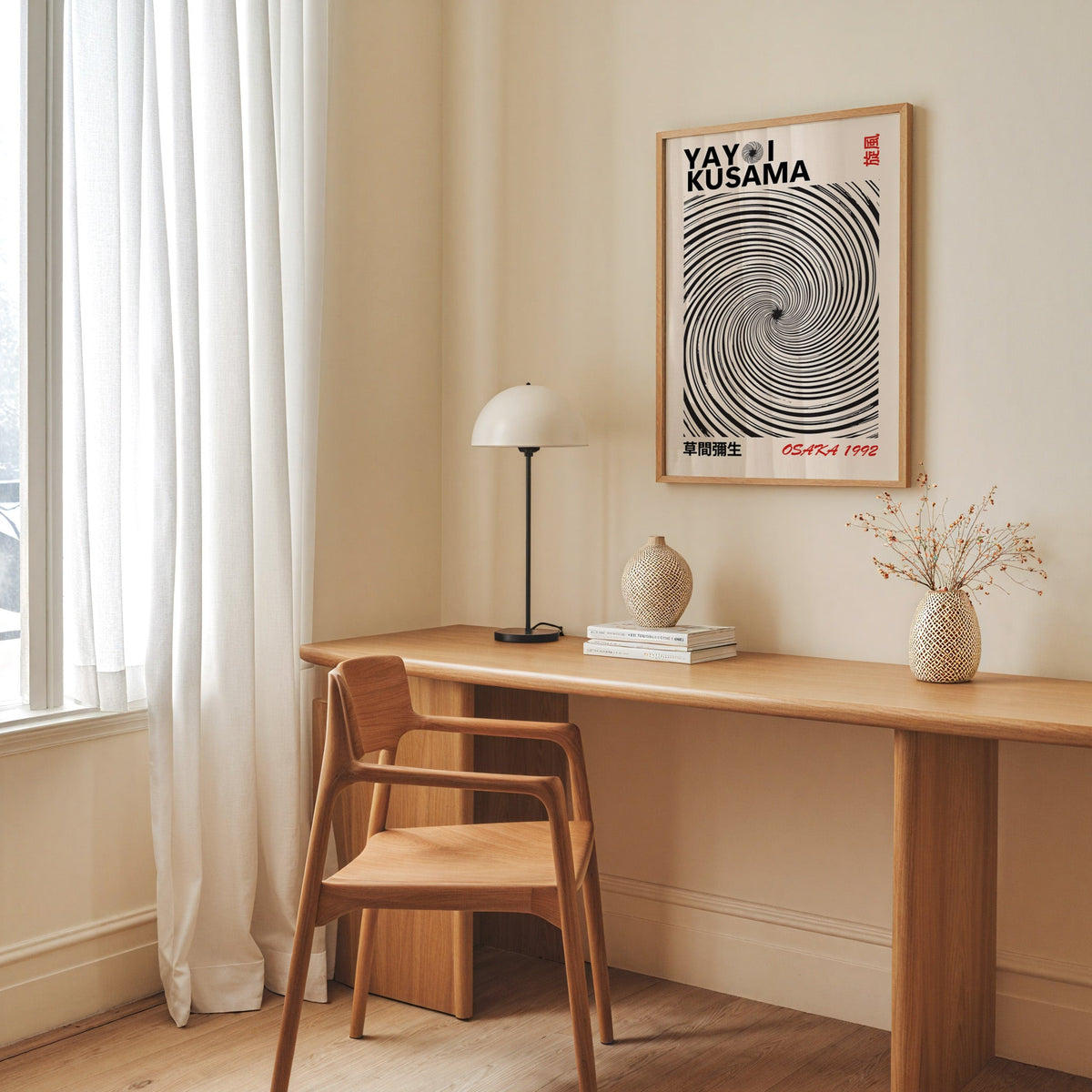 Yayoi Kusama inspired black spiral whirlwind print in an oak frame above an oak desk with a dome lamp