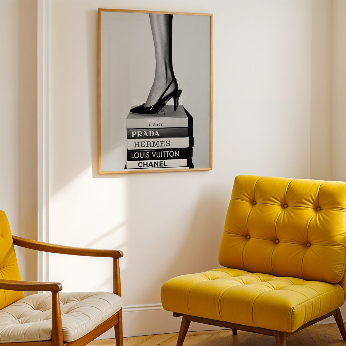 Glossy slingback heel standing on stacked books print shown in a gold frame above a mustard yellow tufted armchair