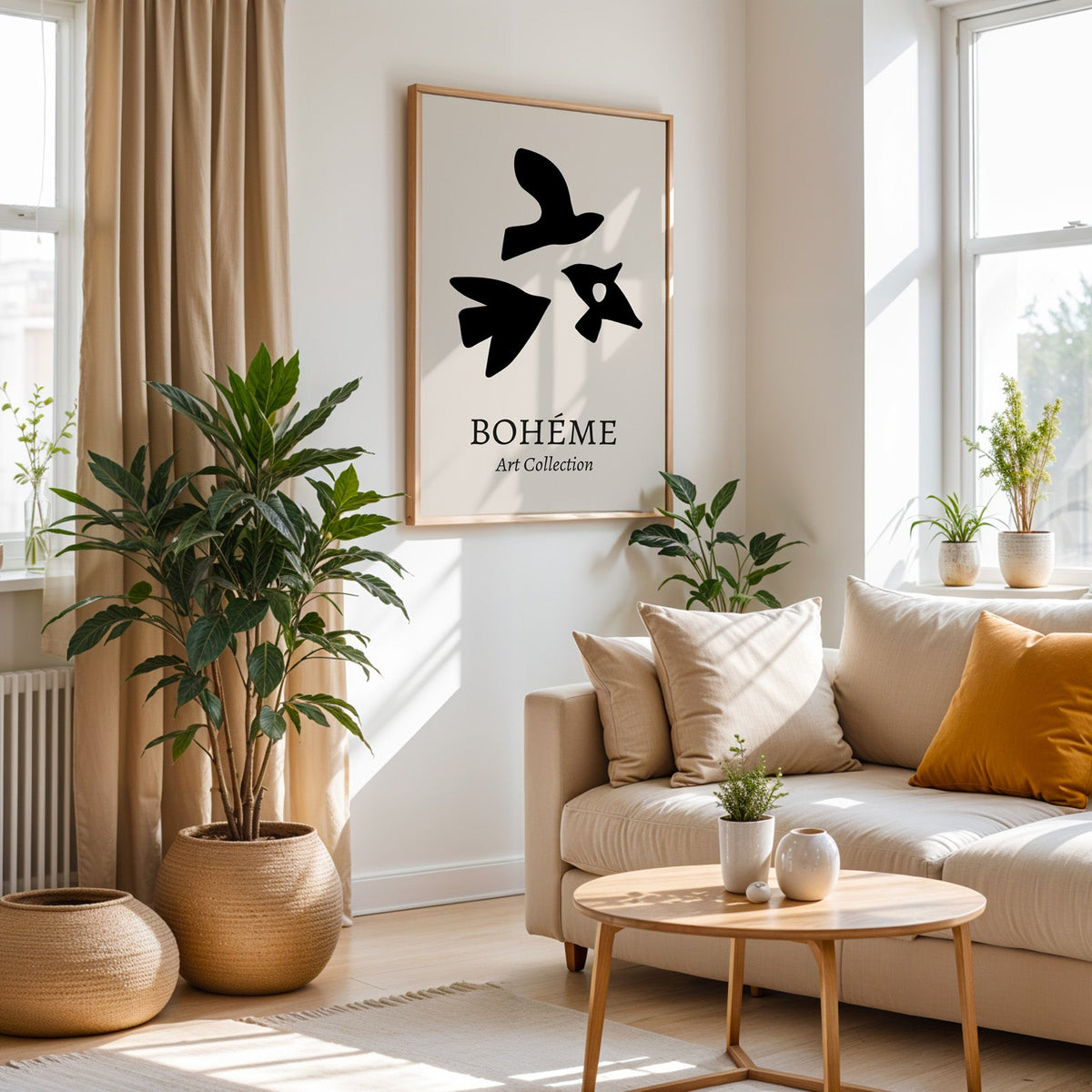 Black three birds cutout abstract print in an oak frame above a cream sofa beside a tall plant in a woven pot