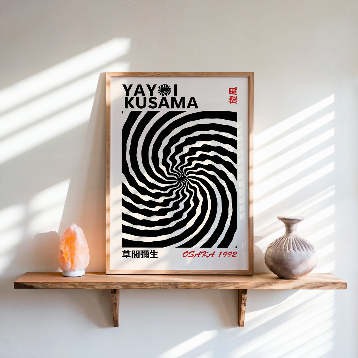 Yayoi Kusama inspired black wave swirl op art print in an oak frame on a live edge shelf beside a salt lamp