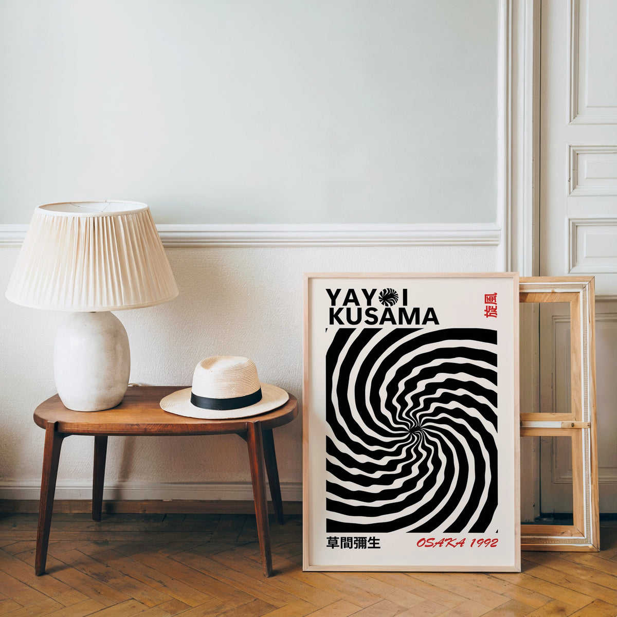 Yayoi Kusama inspired black wave swirl op art print in an oak frame over a bench with a panama hat
