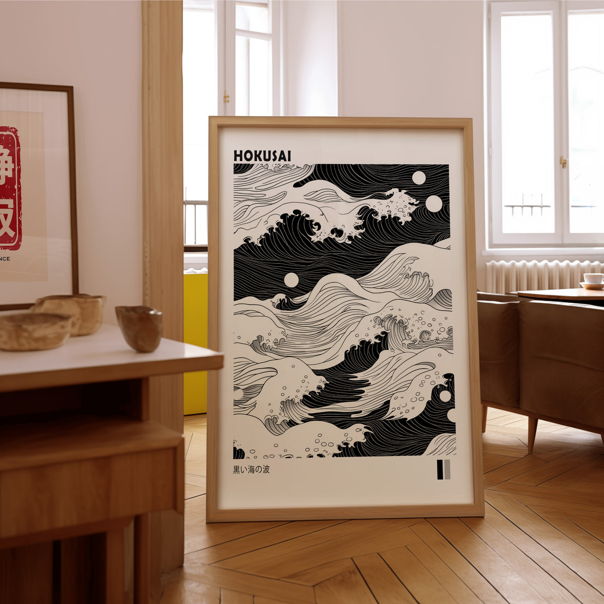 Black sea waves with twin moons print in an oak frame on the parquet floor of a sunlit living room