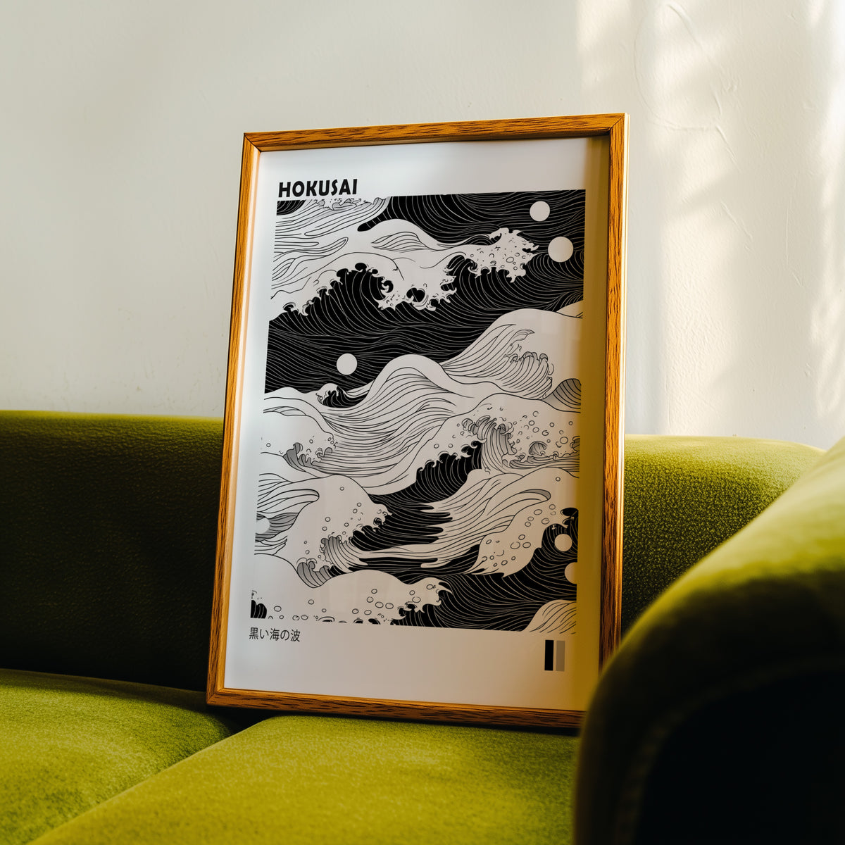 Black sea waves with twin moons print in an oak frame propped on a green velvet sofa