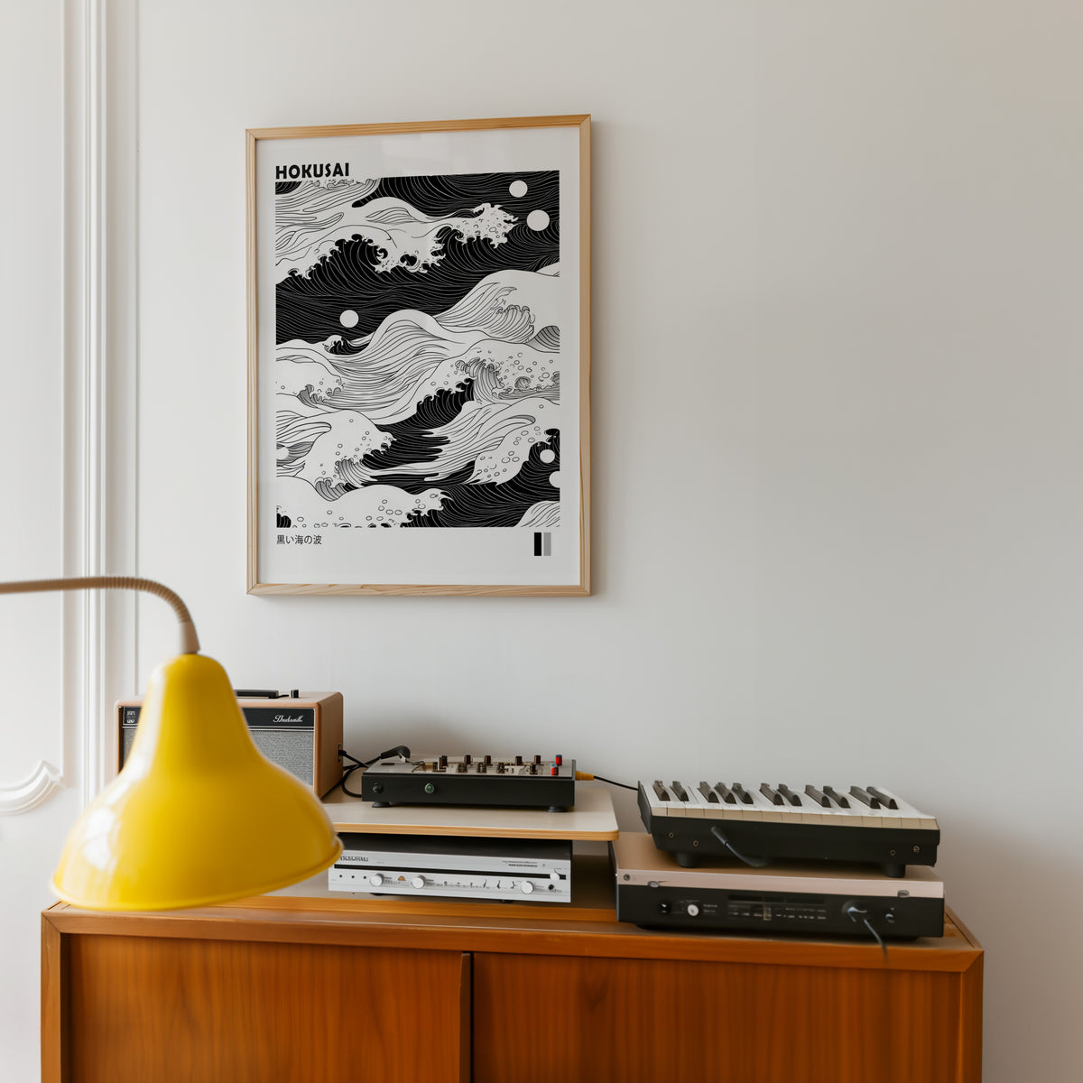 Black sea waves with twin moons print in an oak frame above a teak sideboard with vintage hi-fi