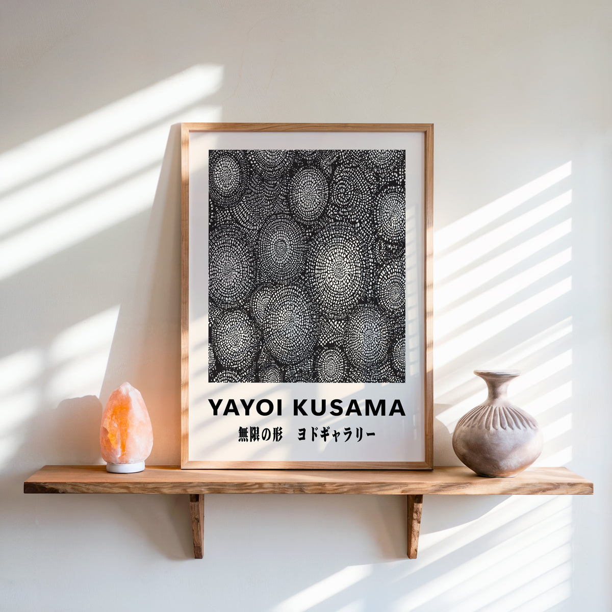 Yayoi Kusama inspired black and white oval net print above a shelf with a salt lamp