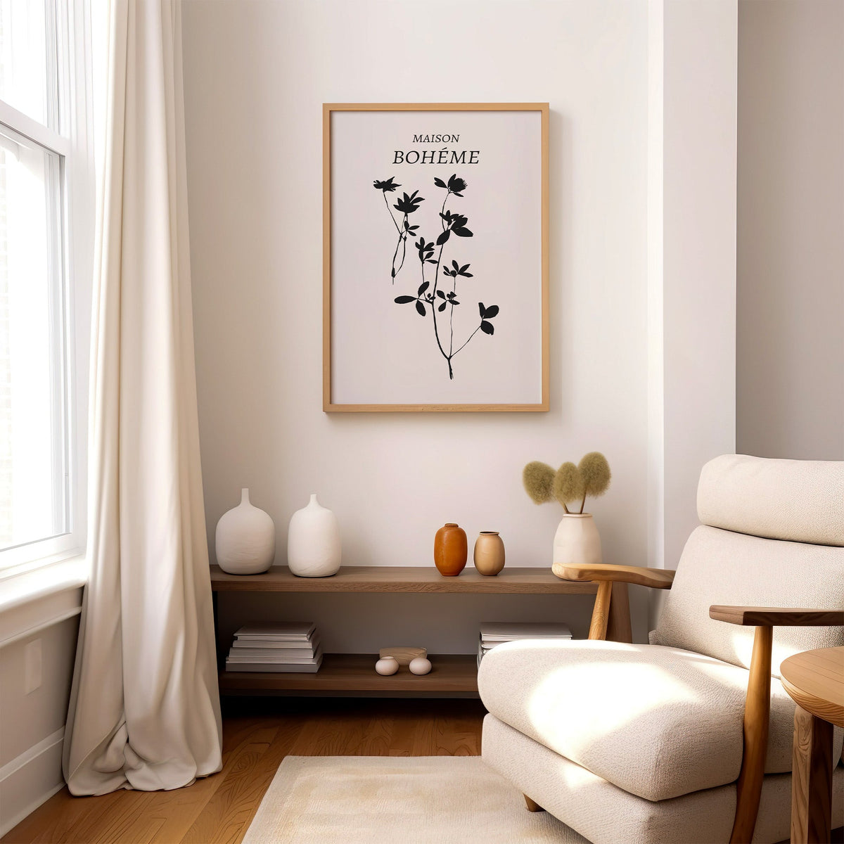 Black wildflower silhouette on cream botanical print in an oak frame above a wood console shelf by a cream boucle armchair