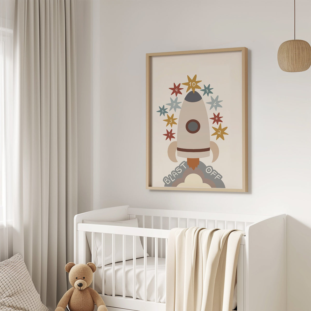 Blast off rocket countdown nursery print in an oak frame above a white crib with a teddy bear