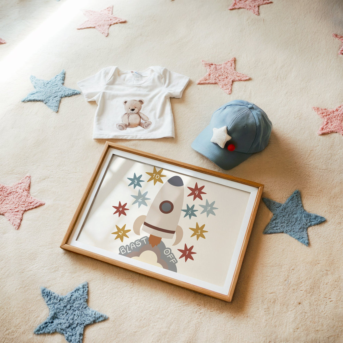 Landscape blast off rocket countdown nursery print in a matted oak frame on a star rug with a baby tee