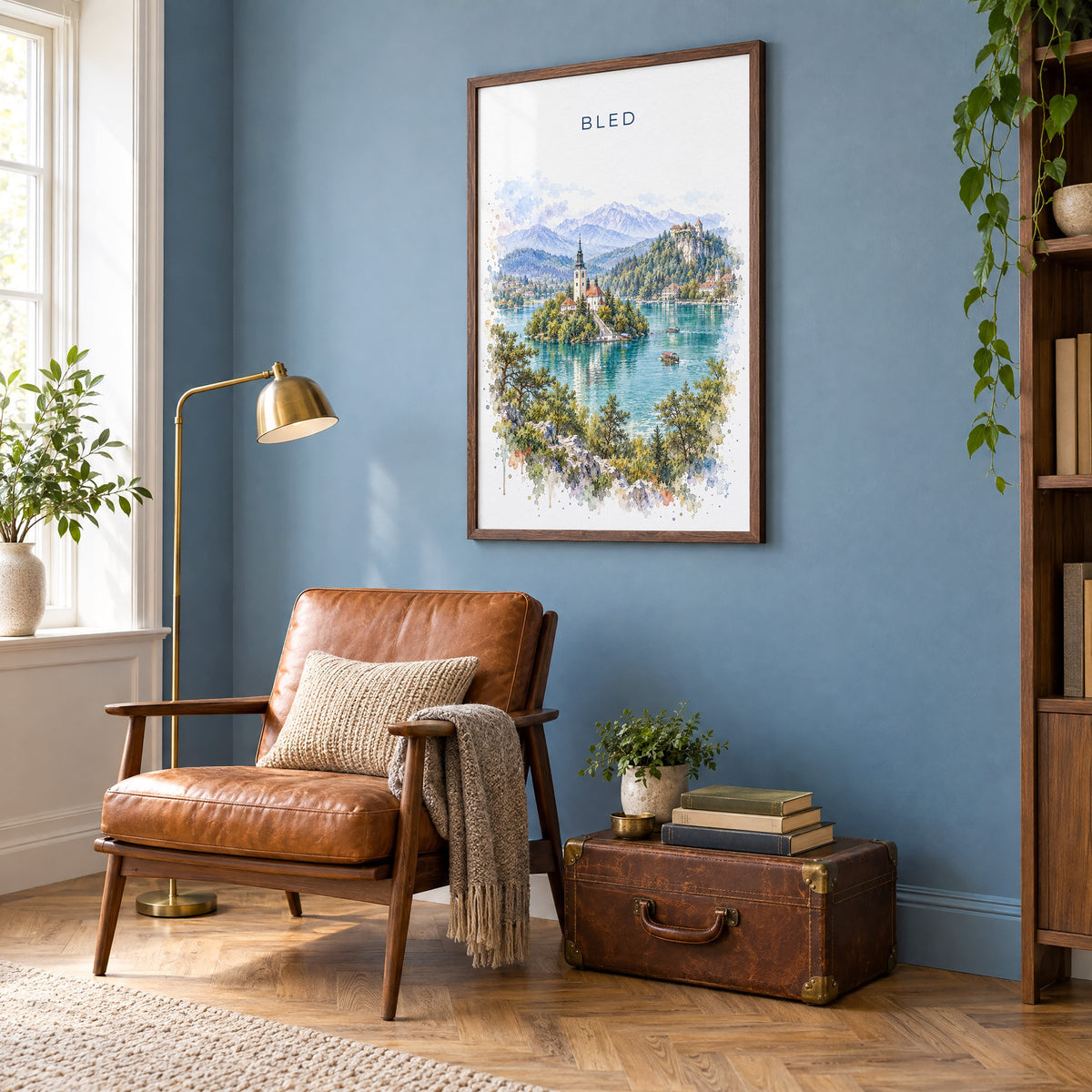 Bled watercolor print in a walnut frame on a blue wall above a leather armchair in a reading nook