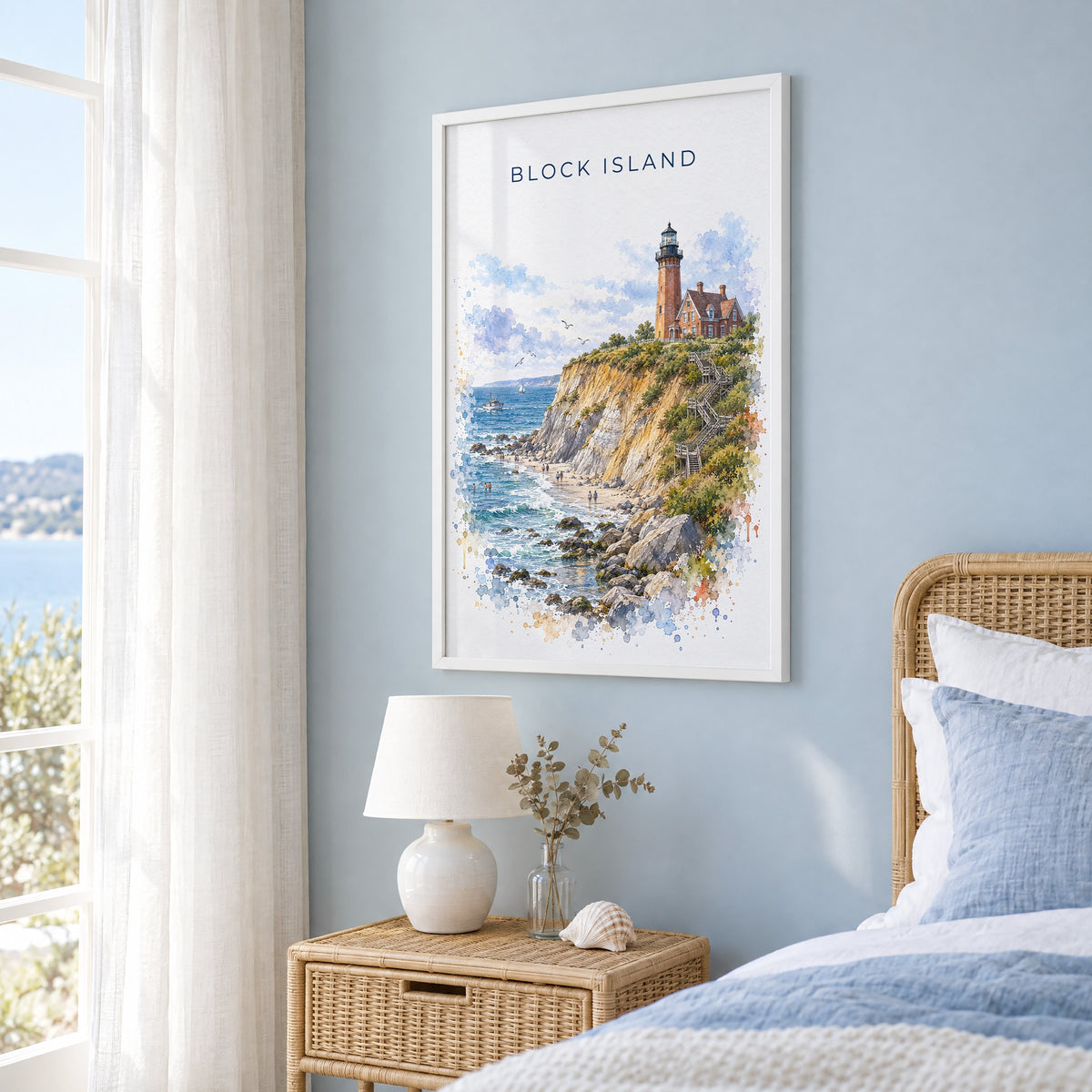 Block Island watercolor print in a white frame on a pale blue wall beside a rattan bed in a coastal bedroom