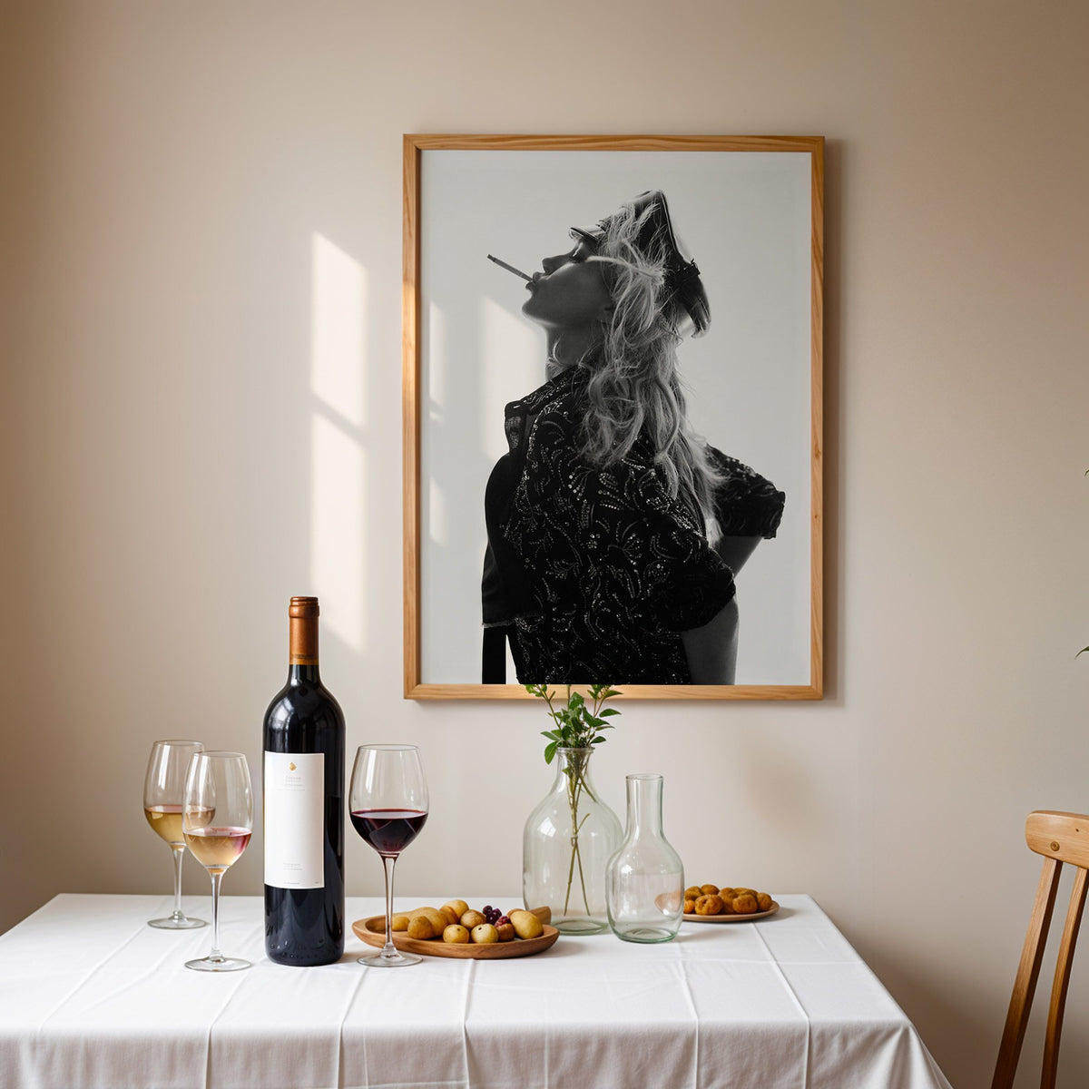 Backlit model in leather cap and sequin jacket print in an oak frame above a table set with red wine and glasses