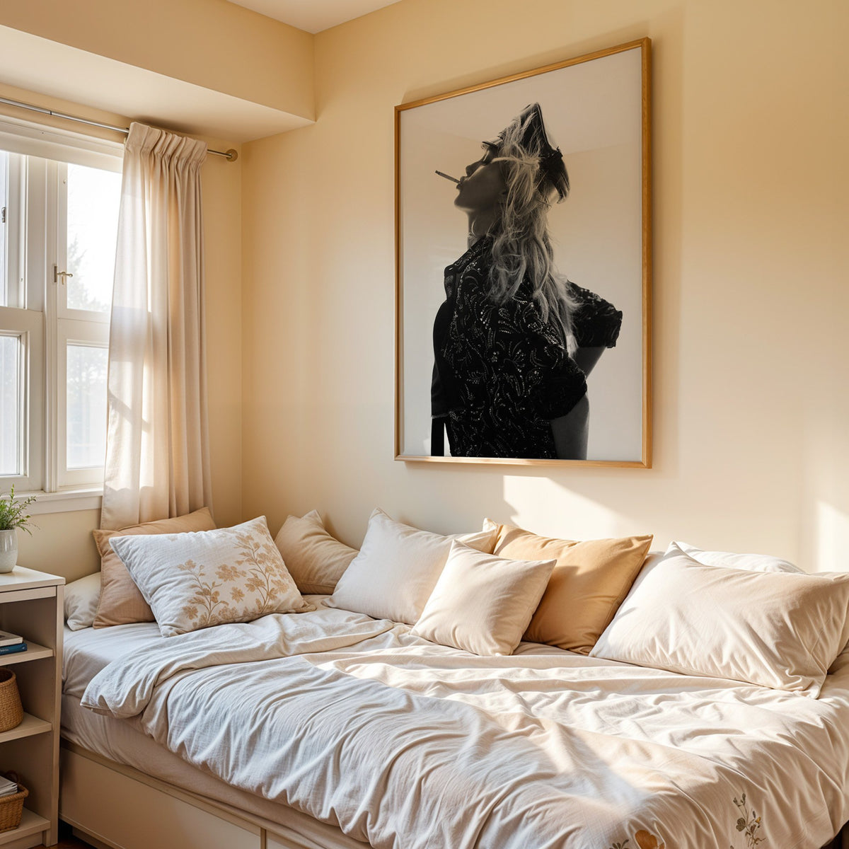 Backlit model in leather cap and sequin jacket print in an oak frame above a cream daybed in a sunny bedroom