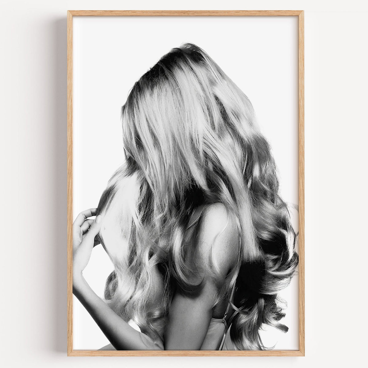 Long blonde wavy hair seen from behind print in a light oak frame on a plain white wall