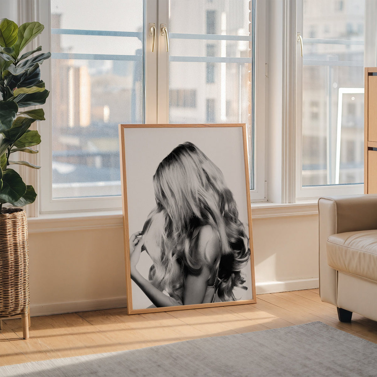 Long blonde wavy hair seen from behind print in an oak frame leaning on the floor beside a fiddle leaf fig